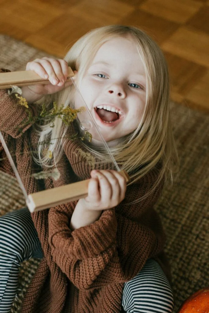 a little girl sitting on the floor holding a book